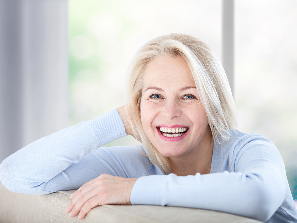 smiling-middle-aged-woman-sitting-on-couch